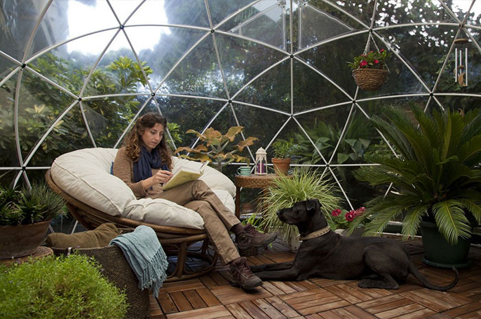 leyendo dentro de un iglú de jardín de cúpula de invernadero