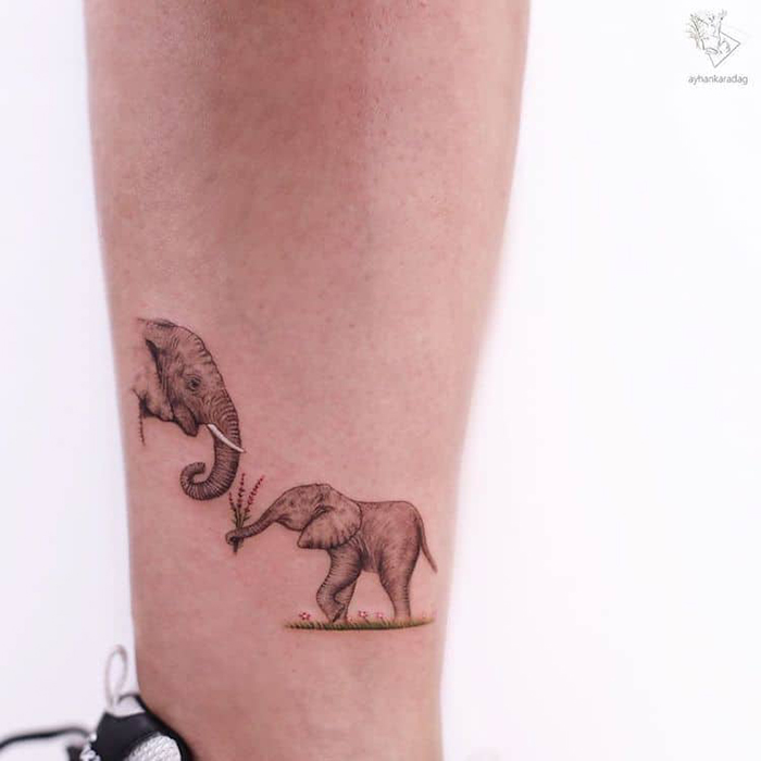 Una cría de elefante presenta un ramo de flores silvestres con su lindo tatuaje