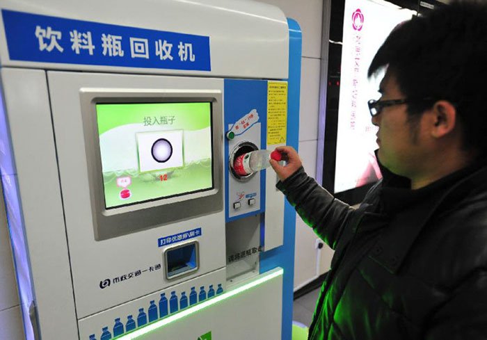 Hombre poniendo botella de plástico en la terminal de pago en el metro de Beijing