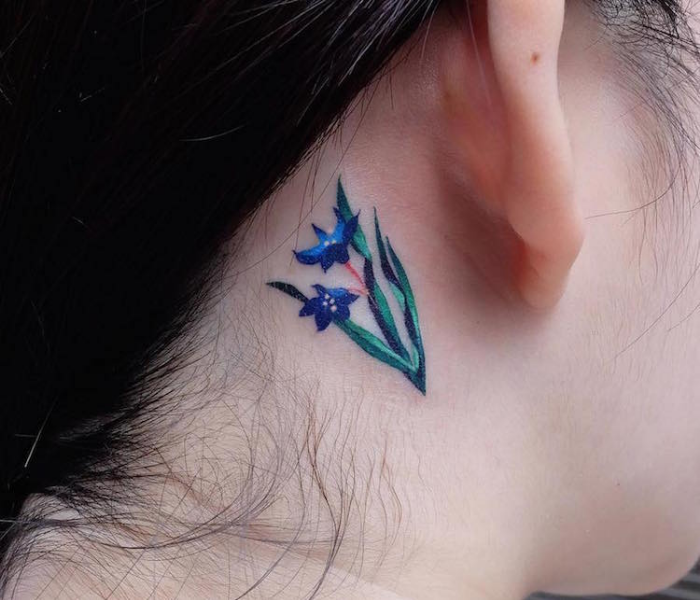 flor azul en el cuello de los mejores tatuadores de flores
