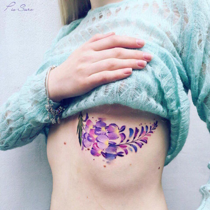 flores púrpuras debajo de los mejores artistas del tatuaje floral en el pecho