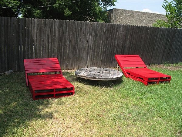 salones rojos al aire libre hechos de paletas de madera con mesa circular  