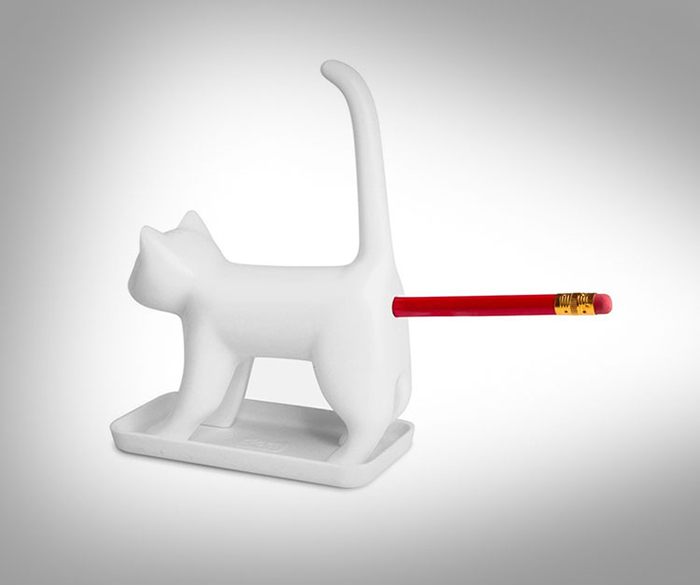 Un lápiz rojo en la punta afilada del gato blanco