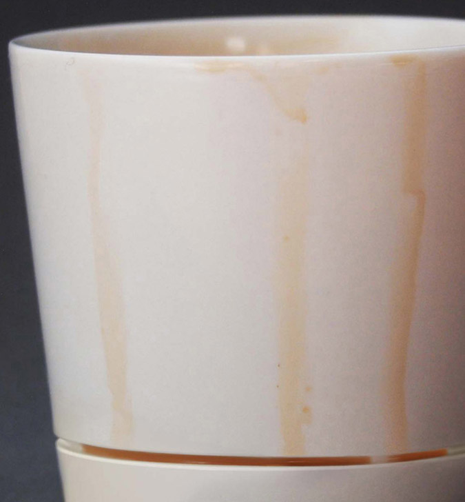 cierre las gotas de café en la taza de café con captura de goteo